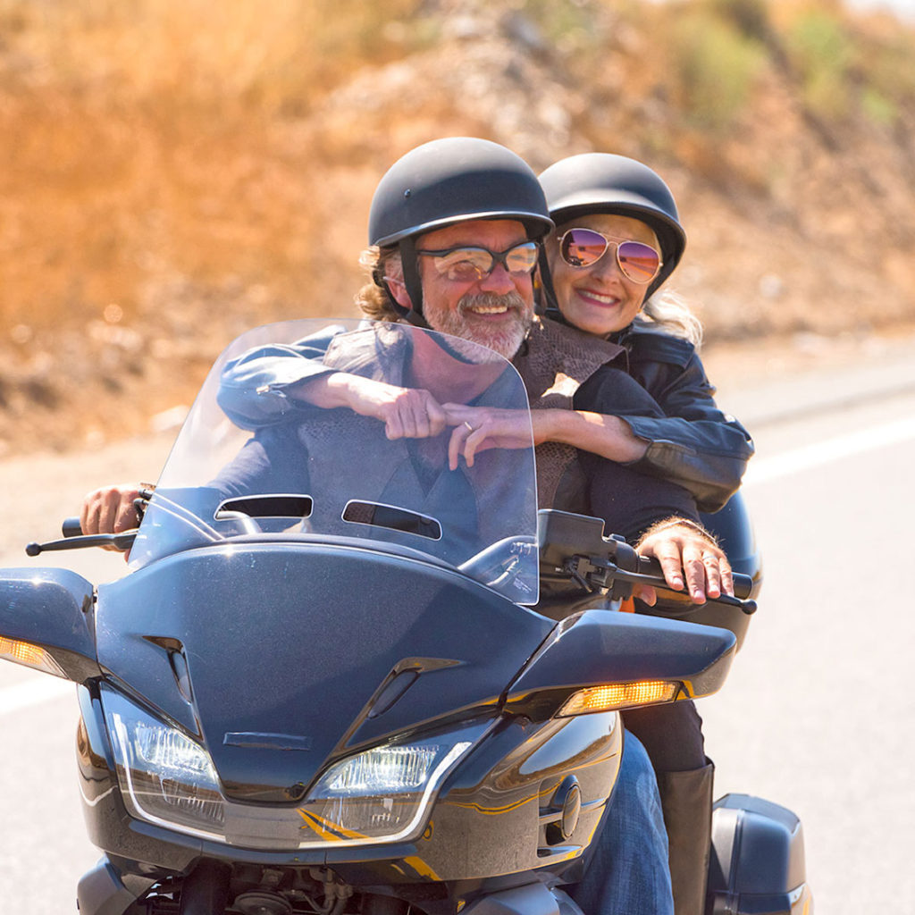 Happy senior man and woman on motorcycle