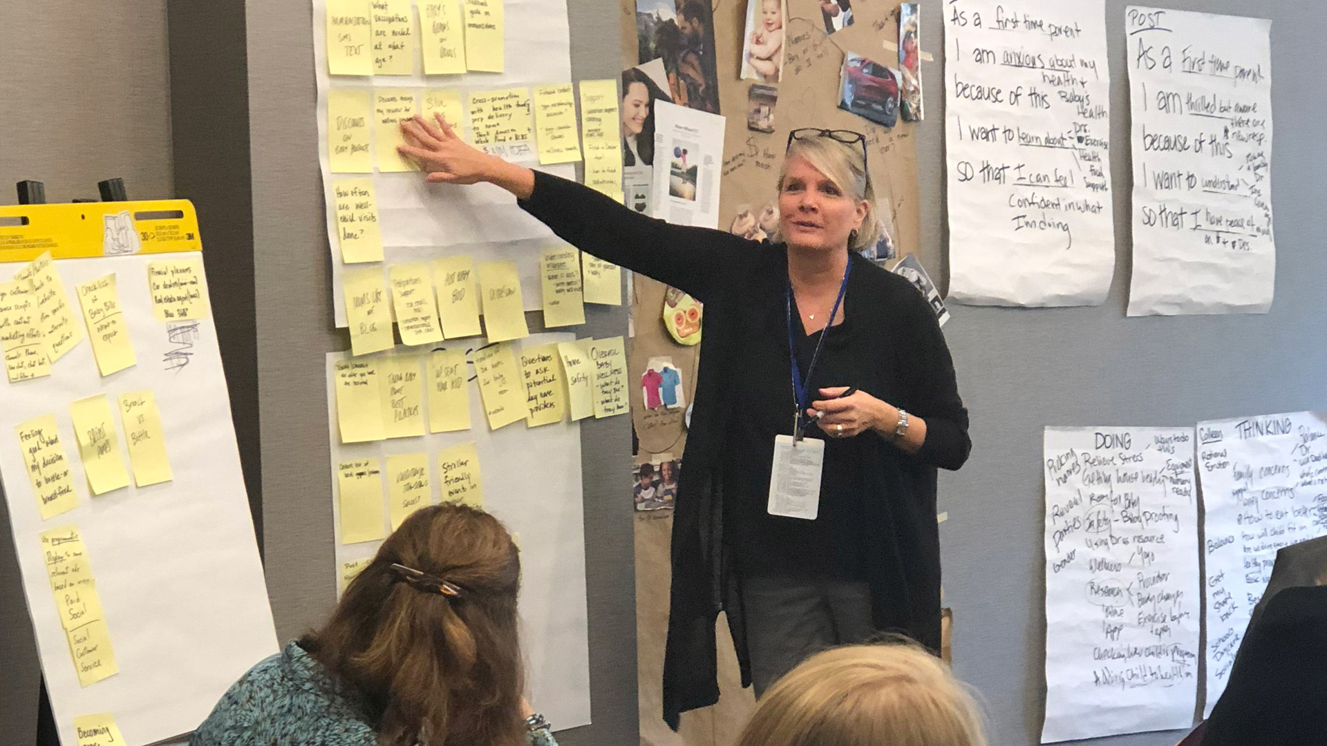 ZLR Ignition CEO and President Xan McNelly gestures toward a wall of notes with data while leading a group discussion on brand reputation.