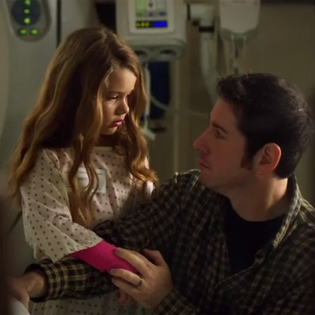 Man comforting daughter near MRI machine