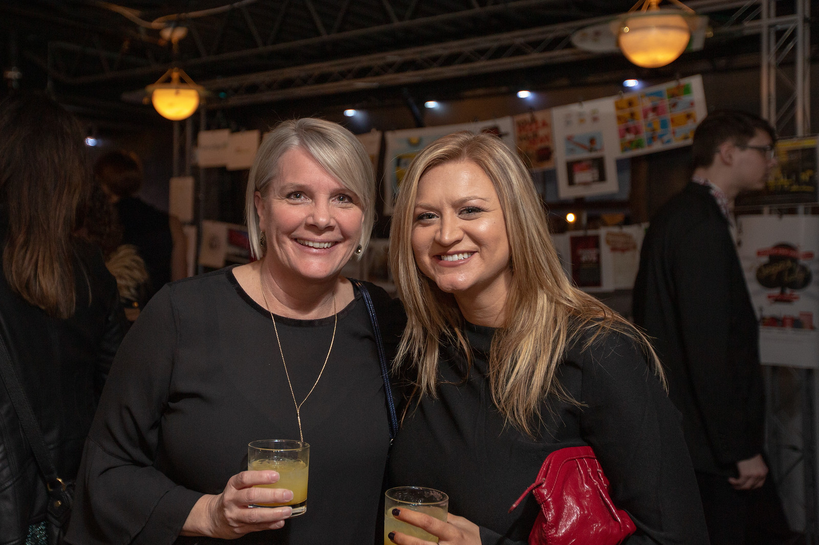 Two women standing together and smiling.